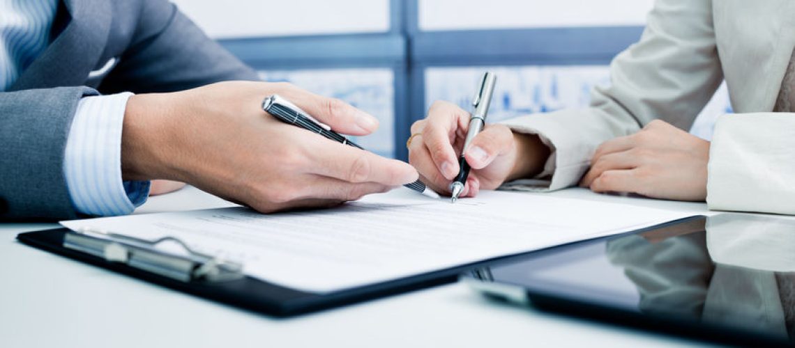 Female hand signing contract.