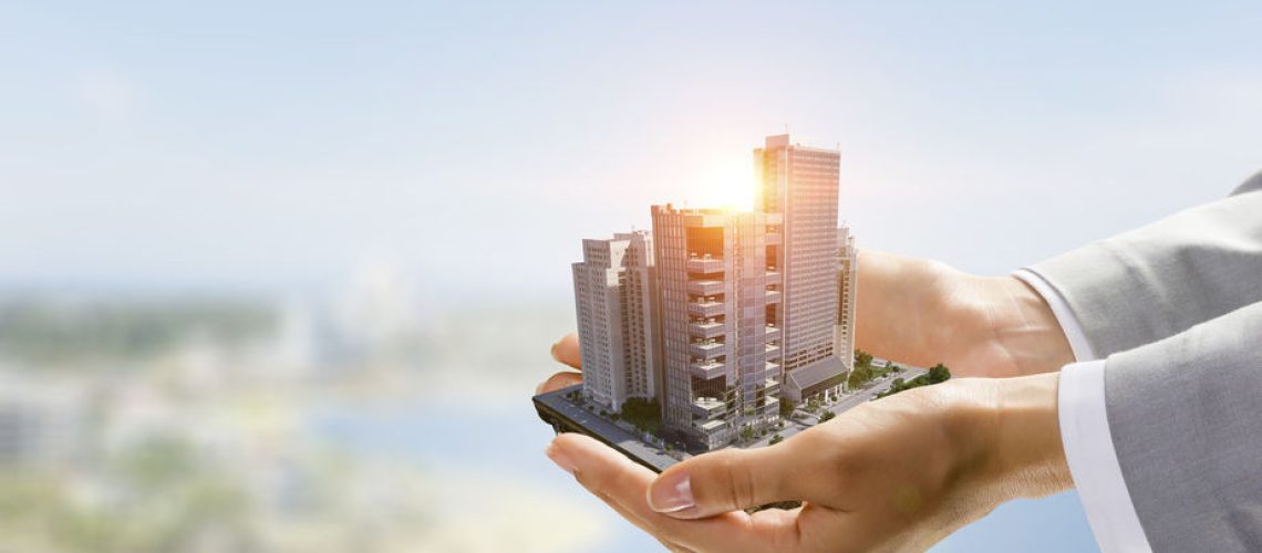 Close up of businesswoman hand holding construction model. Mixed media